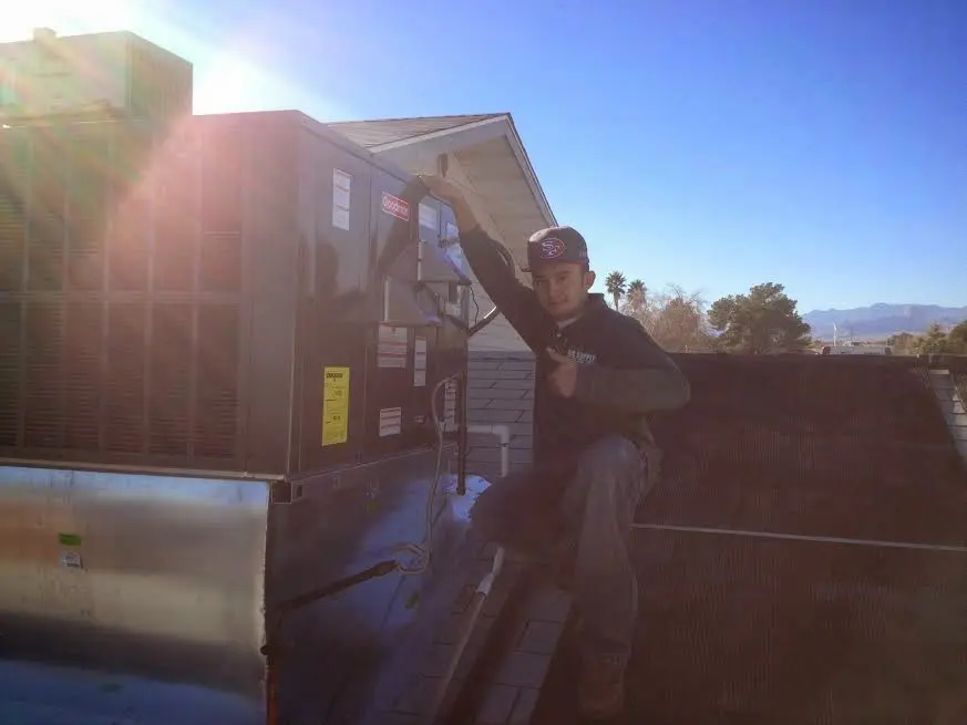 HVAC technician performing AC Tune-Up on a rooftop unit in Parkway
